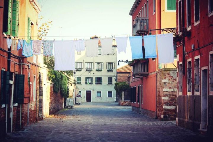 A narrow street of colourful houses with laundry lines